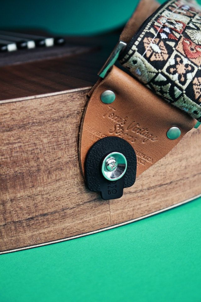 Find the strap buttons on each side of the body of the guitar